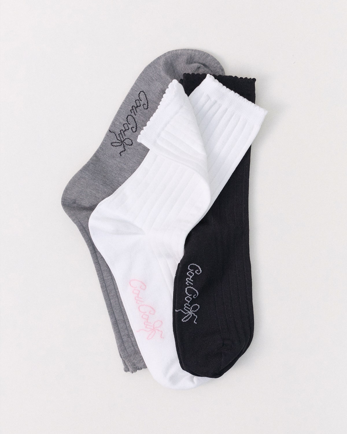 Three pairs of socks in gray, white, and black with text on a light gray background