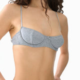 Gray bra worn by a model on a white background