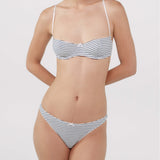 A woman modeling a two-piece bra and thong with thin horizontal navy and white stripes.