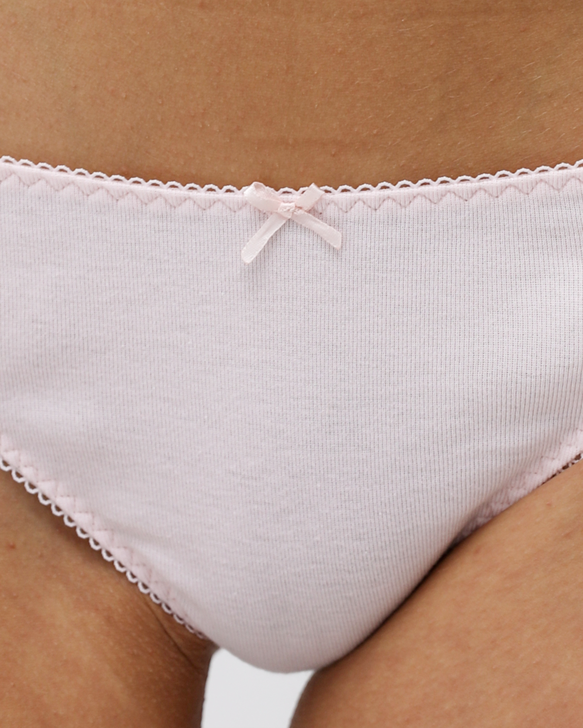 Close-up of a person wearing light pink underwear with lace trim.