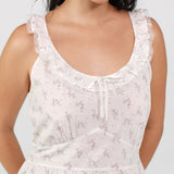White floral dress worn by a model on a light gray background
