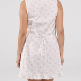 White sleeveless dress with floral pattern on a plain background