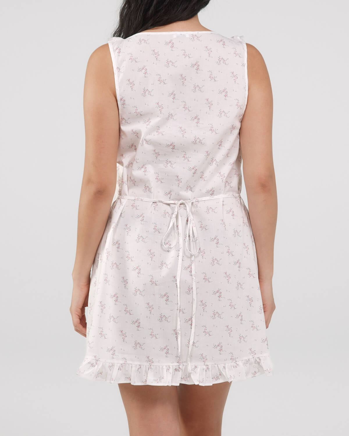 White sleeveless dress with floral pattern on a plain background