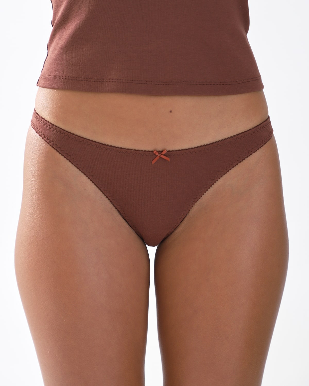 Brown thong worn by a person on a white background