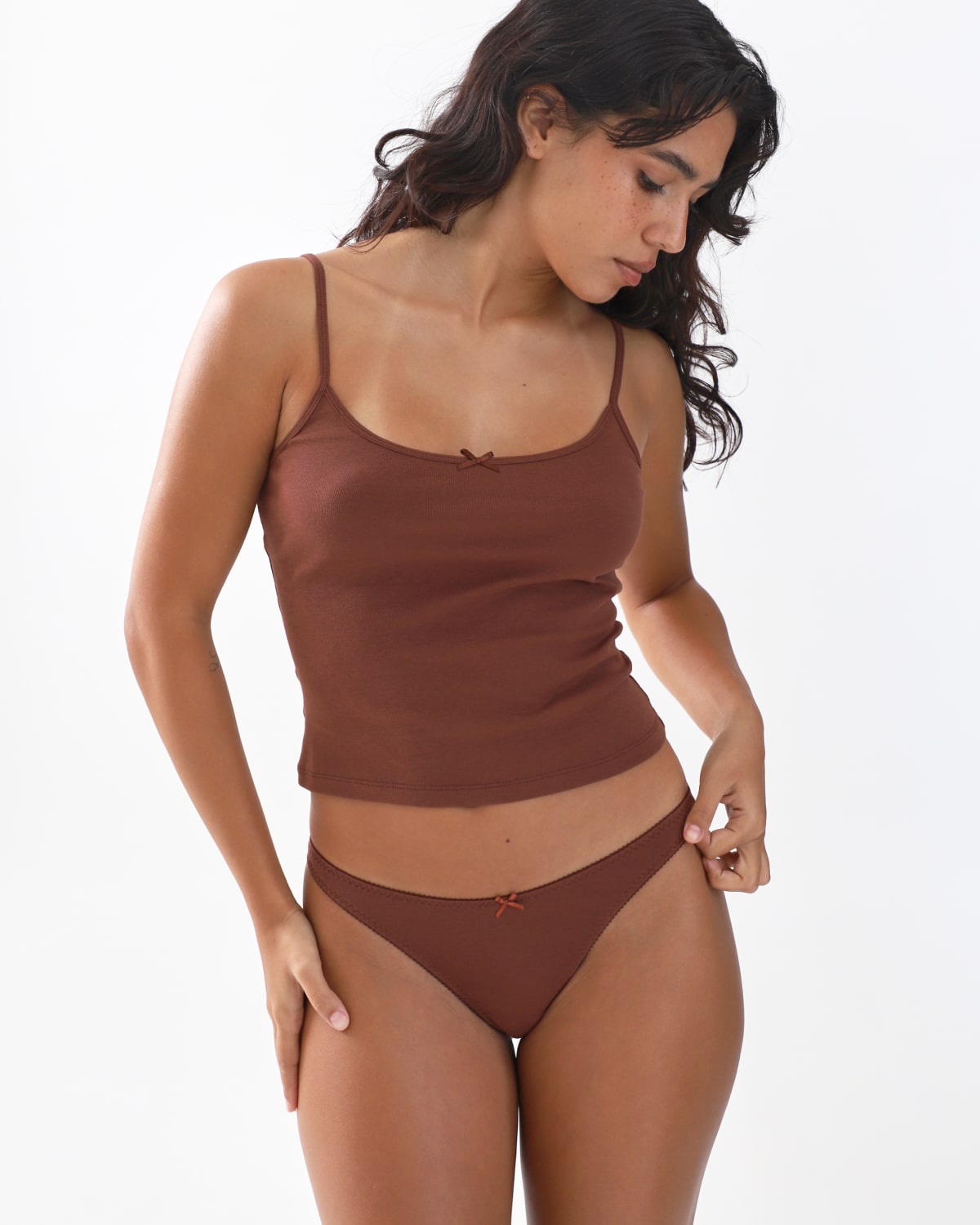 Woman wearing a brown tank top and underwear set on a white background
