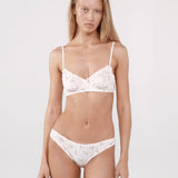 Woman wearing a white lace bra and panties set.
