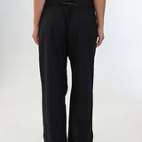 Person wearing black wide-leg pants on a white background