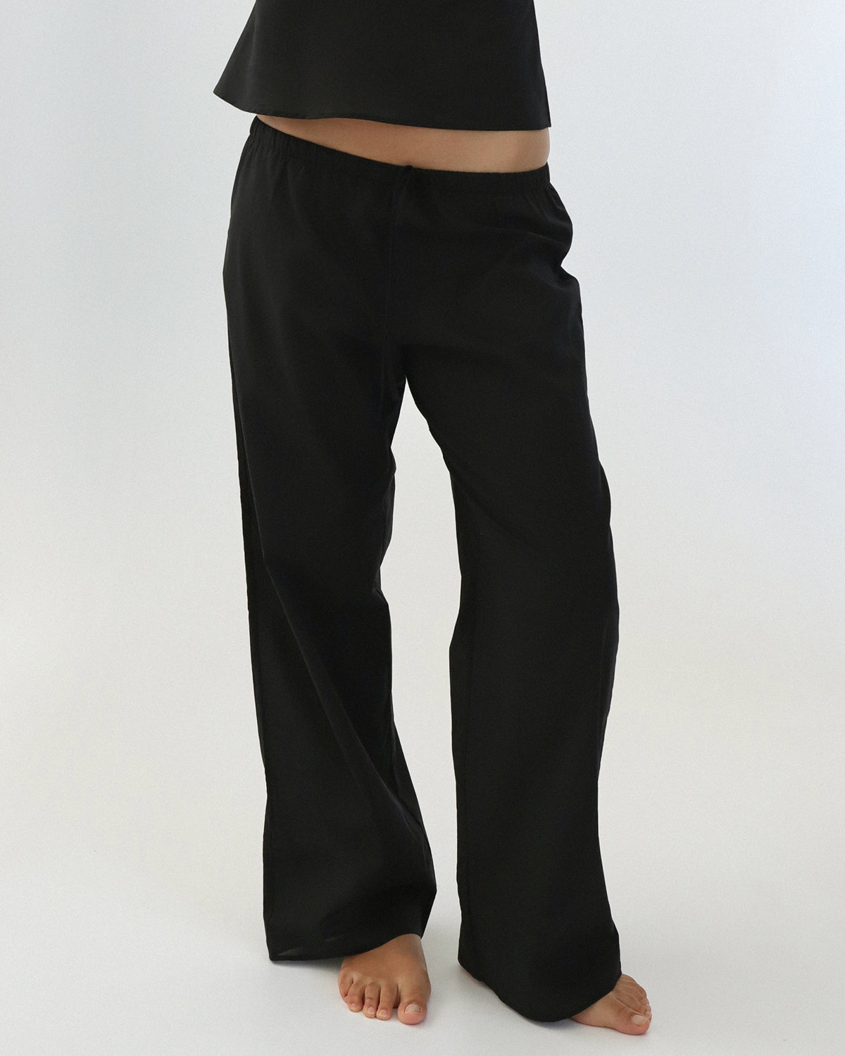 Black pants worn by a person on a white background