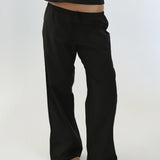 Black pants worn by a person on a white background