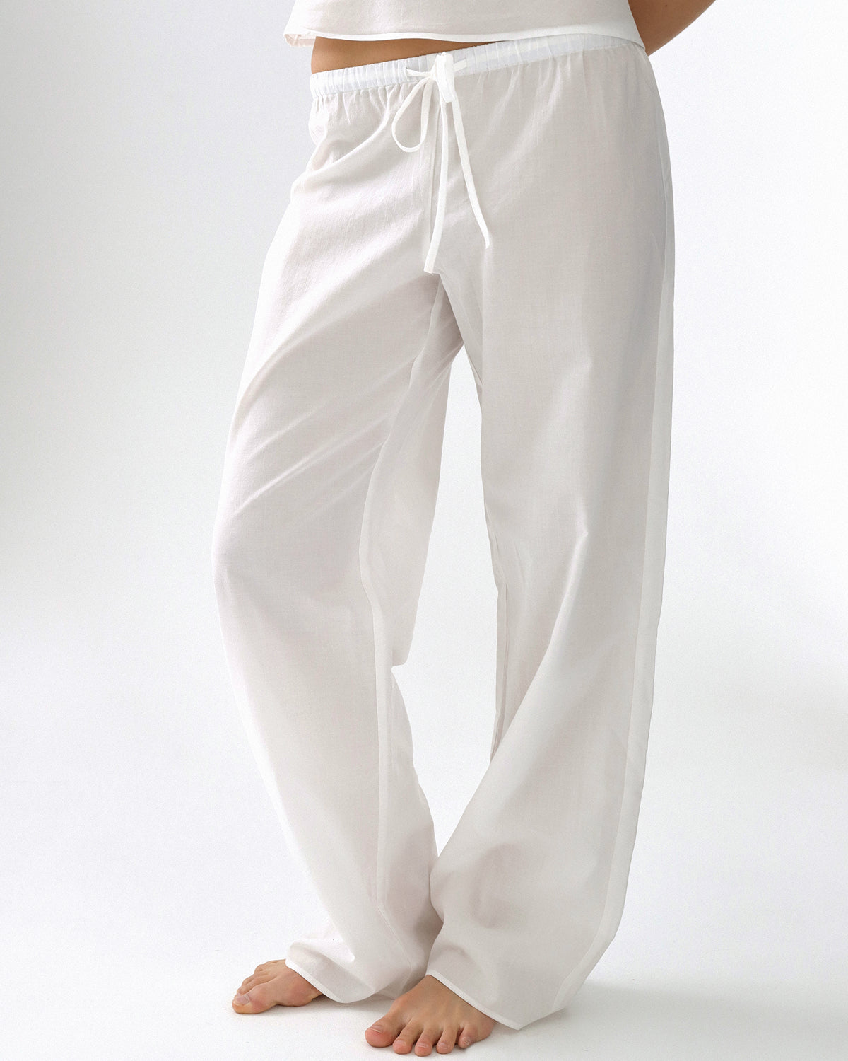 White wide-leg pants worn by a person on a white background