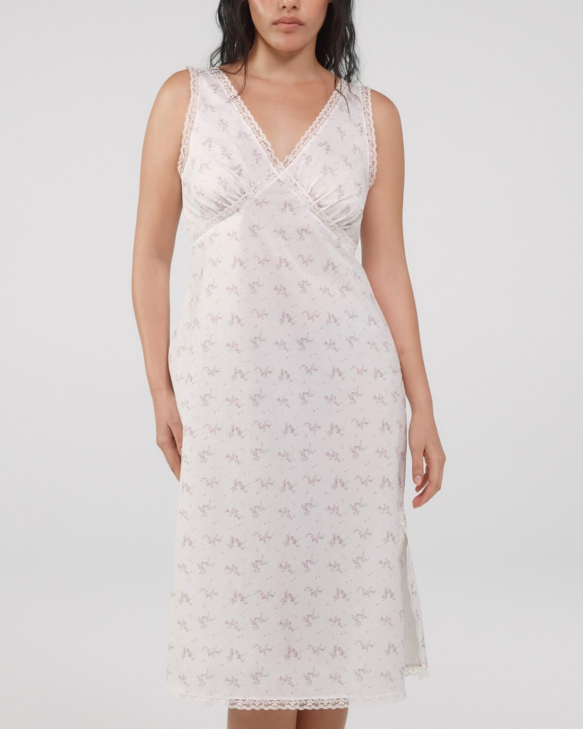 Woman wearing a white lace nightgown against a plain background