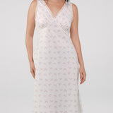 Woman wearing a white lace nightgown against a plain background
