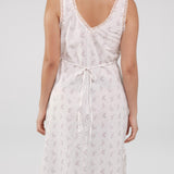 White floral dress worn by a person on a plain background