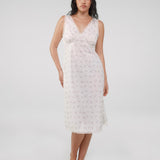 Woman wearing a white lace nightgown against a plain background