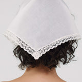White bonnet with lace trim on a plain background