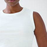 White sleeveless top worn by a person on a white background