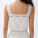 White lace top worn by a person on a plain background