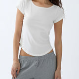 Woman wearing a white t-shirt and gray pants on a white background